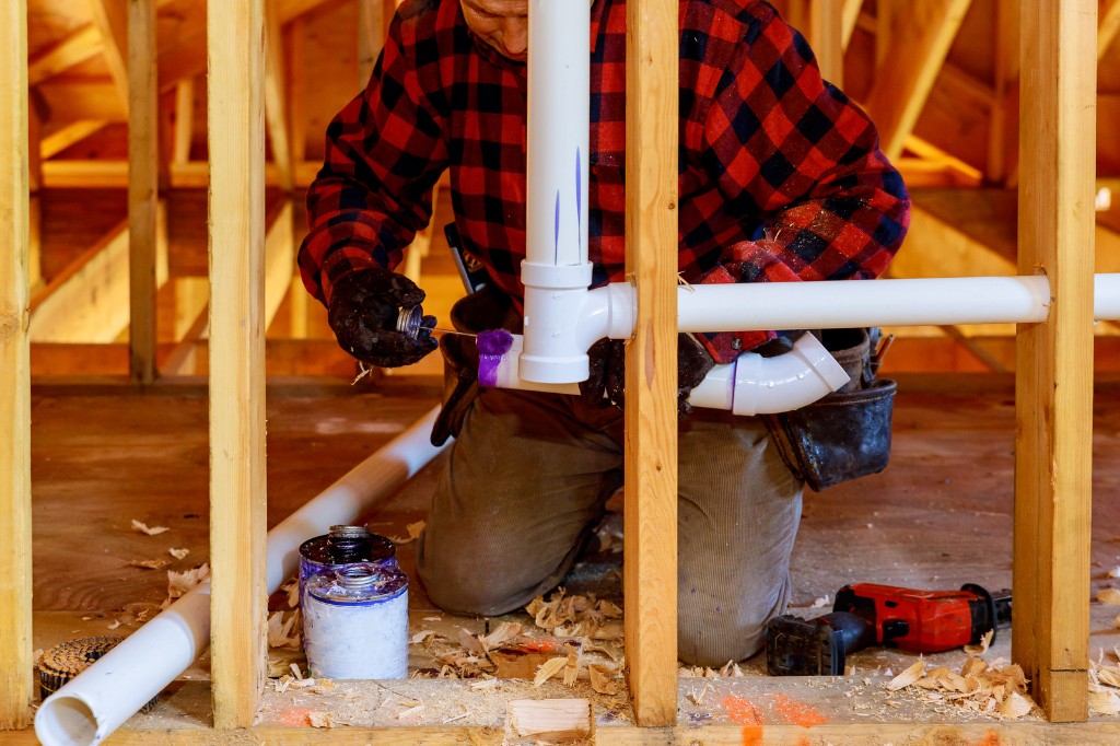 Plumber working on pipe connections