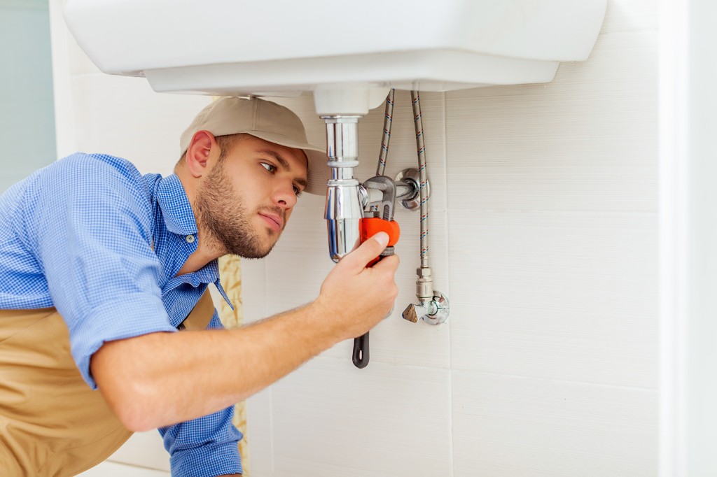 Plumber installing new pipes in a home
